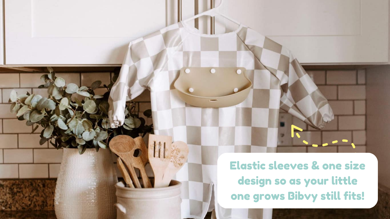 Bibvy's adjustable one-size bib with elastic sleeves showcased in a kitchen, emphasizing that it grows with your child.