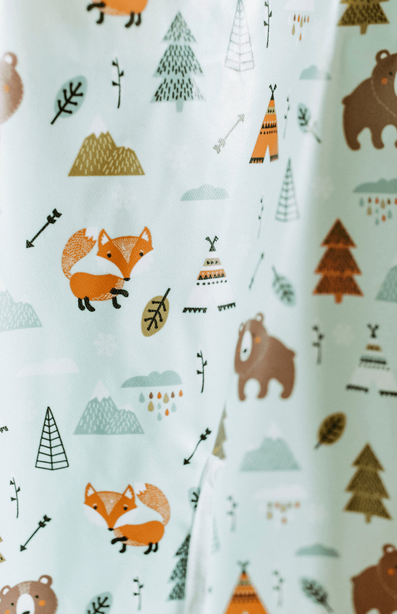 Close-up view of the Bibvy bib featuring the 'Wilderness Wonder' print with foxes, bears, and teepees.